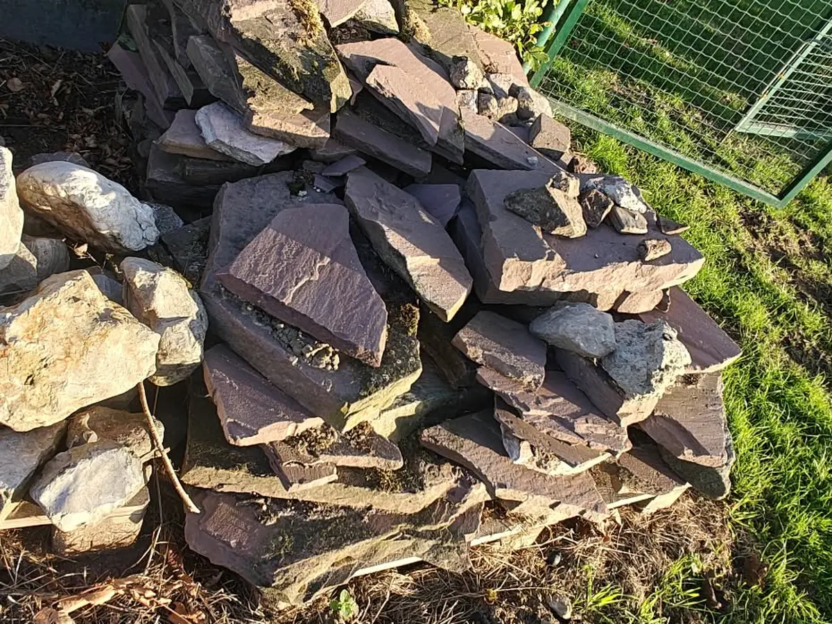 Natuursteen en rotsblokken gestapeld naast de haag
